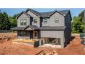 The gray exterior of this new two-story home has an open garage and a charming front porch at 272 1St Ave, Avondale Estates, GA 30002