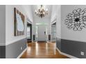 Bright foyer featuring hardwood floors, chandelier, wainscoting, and decorative wall art at 1377 Downington Nw Ln, Acworth, GA 30101