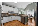 Cozy kitchen with white cabinets, stainless appliances, granite counters, and hardwood floors at 1377 Downington Nw Ln, Acworth, GA 30101