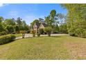 Lovely lawn with flowering bushes and a brick home on a sunny day at 1750 Providence Place Dr, Alpharetta, GA 30009