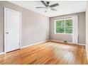 Cozy bedroom featuring hardwood floors, a ceiling fan, and a large window with a wooded view at 2714 Laurel Ridge Dr, Decatur, GA 30033