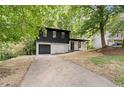Beautiful split-level home with stone accents, a black garage door, and a long driveway at 5401 Martins Crossing Rd, Stone Mountain, GA 30088