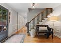 Inviting foyer featuring hardwood floors, staircase with iron railings, and bench seating at 960 Lost Forest Dr, Sandy Springs, GA 30328