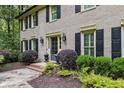 Charming brick home featuring mature landscaping, black shutters and a welcoming front entrance at 960 Lost Forest Dr, Sandy Springs, GA 30328