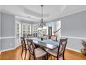 Elegant dining room with tray ceiling, wainscoting, and bay window overlooking the yard at 947 Summer Forest Drive, Suwanee, GA 30024