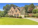 View showcasing the home's side elevation, three-car garage, and well-maintained landscaping at 947 Summer Forest Drive, Suwanee, GA 30024