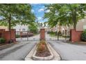 Gated community entrance with brick pillars, beautiful landscaping, and secure access at 1300 Hopkins Dr, Decatur, GA 30033