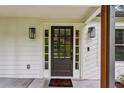 Close up of a black, glass paneled front door with sidelights, black hardware and wall lanterns at 232 Apple Branch Dr, Woodstock, GA 30188