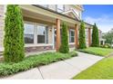 Welcoming covered front porch featuring stone accents, wood columns, and manicured landscaping at 411 Ridgeway Ln, Canton, GA 30114