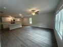 Bright and airy living room with hardwood floors, large windows, and a view of the modern kitchen at 35 Yellow Brick Way, Covington, GA 30014