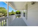 Front porch featuring gray wood flooring, white columns, and wood siding at 6275 Cheatham Lake Nw Dr, Acworth, GA 30101