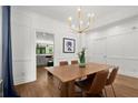 Elegant dining room with modern lighting, wood floors, and decorative wainscoting at 1744 Habershal Nw Dr, Atlanta, GA 30318