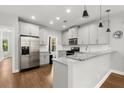 Charming kitchen features stainless steel appliances, granite countertops, and white cabinets at 1744 Habershal Nw Dr, Atlanta, GA 30318
