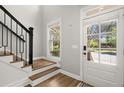Bright entryway featuring stairs with sleek black railings and a sunlit front door at 1744 Habershal Nw Rd, Atlanta, GA 30318