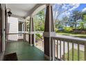 Inviting front porch with classic columns, painted floor, and a glimpse of the neighborhood at 1744 Habershal Nw Rd, Atlanta, GA 30318