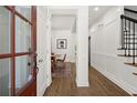 Inviting hallway with hardwood floors and elegant white wainscoting leading to a dining area at 1744 Habershal Nw Rd, Atlanta, GA 30318