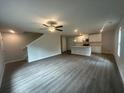 Open concept living room featuring hardwood floors, a ceiling fan, and seamlessly connected to the kitchen at 75 Emerald Ln, Covington, GA 30014