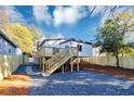 Newly renovated backyard with a wooden deck and stairs leading down to gravel and mulched areas at 923 Smith Sw St, Atlanta, GA 30310