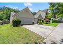 Inviting home with a two-car garage, lush lawn, and a beautifully landscaped yard at 2125 Mina Lane Dr, Buford, GA 30518