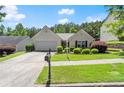Charming home featuring a well-maintained lawn, mature landscaping, and a paved driveway at 2125 Mina Lane Dr, Buford, GA 30518