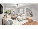 Bright living room with contemporary furnishings, ceiling fan, and open staircase access at 2340 Beaver Ruin Rd # 68, Norcross, GA 30071