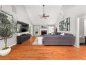 Open living room with hardwood floors, vaulted ceiling, stone fireplace, and abundant light at 2835 Channing Way, Cumming, GA 30040
