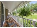 Relaxing front porch with comfortable seating and a hanging fern basket at 5107 Old Chestnut Ct, Woodstock, GA 30188