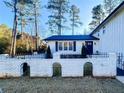 Charming home exterior featuring a decorative brick fence and manicured landscaping at 110 Randomwood Way, Alpharetta, GA 30022