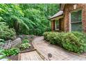 Beautifully landscaped walkway featuring brick pavers, stacked stone retaining wall, and mature plantings at 5765 Riley Rd, Cumming, GA 30028
