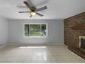 Bright living room featuring a brick fireplace, ceiling fan, and large windows at 6389 Cumberland Dr, Rex, GA 30273