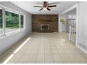 Spacious living room with a brick fireplace, tile floors, and lots of natural light at 6389 Cumberland Dr, Rex, GA 30273