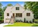 Charming home with a white brick exterior, complemented by a well-maintained lawn and landscaped garden at 1327 Harvard Ne Rd, Atlanta, GA 30306
