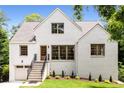 Beautiful, bright home boasts white brick, green yard, and stately staircase leading to the front door at 1327 Harvard Ne Rd, Atlanta, GA 30306