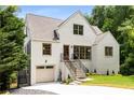 Elegant white brick home showcasing a landscaped yard, attached garage, and inviting front steps at 1327 Harvard Ne Rd, Atlanta, GA 30306