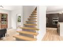 Modern, light-filled home featuring natural wood floating staircase and sight-lines into the kitchen at 1327 Harvard Ne Rd, Atlanta, GA 30306