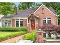 Charming brick home featuring a well-manicured lawn and a brick walkway leading to the front door at 228 Clarion Ave, Decatur, GA 30030