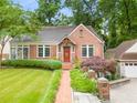 Charming brick home featuring a well-manicured lawn and a brick walkway leading to the front door at 228 Clarion Ave, Decatur, GA 30030