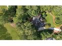 Aerial view of a home nestled among lush trees, surrounded by green spaces, creating a private and serene environment at 5040 Harrington Rd, Johns Creek, GA 30022