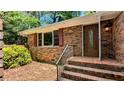 Inviting brick front entrance with decorative front door and windows featuring red shutters at 3656 Salem Trl, Lithonia, GA 30038