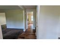 Hallway featuring neutral paint, durable wood-look flooring and views into the living room and kitchen at 3656 Salem Trl, Lithonia, GA 30038