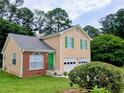 Charming exterior elevation of two-story home with green shutters and a two-car garage at 5517 Rock Shoals Way, Atlanta, GA 30349
