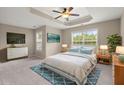 Bright main bedroom with a tray ceiling, ceiling fan, and large window at 212 Ranier Court, Canton, GA 30114