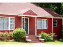 Close up of inviting red brick home with decorative door and manicured landscaping at 3020 Washington Rd, East Point, GA 30344