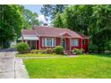 Quaint red brick home featuring a well-kept lawn and mature trees in a lovely neighborhood at 3020 Washington Rd, East Point, GA 30344