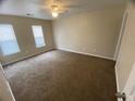 Spacious carpeted bedroom with two windows and a ceiling fan at 6448 Charter Way, Lithonia, GA 30058