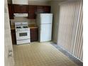Basic kitchen with white appliances, wood cabinets and a window to the outside at 6448 Charter Way, Lithonia, GA 30058