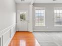 Inviting entryway featuring hardwood flooring, a well-lit view through the front door and carpeted living area at 8750 Radford Ln, Suwanee, GA 30024
