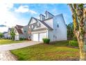 Side view of a two-story home with a well-manicured lawn, showcasing its siding and attached two-car garage at 8750 Radford Ln, Suwanee, GA 30024