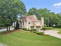 Well-manicured lawn highlights a home with large trees and a circular driveway with basketball hoop at 125 Savannah Estates Dr, Atlanta, GA 30350