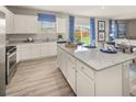Well-lit kitchen with granite countertops, island, stainless steel appliances, and view to the backyard at 237 Paisley Way, Locust Grove, GA 30248
